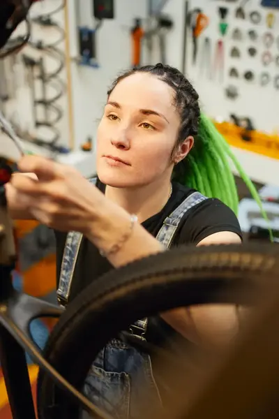 Student sleutelt aan fiets in werkplaats.