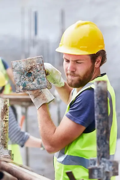 Bouwvakker sjouwt steigeronderdeel op bouwplaats