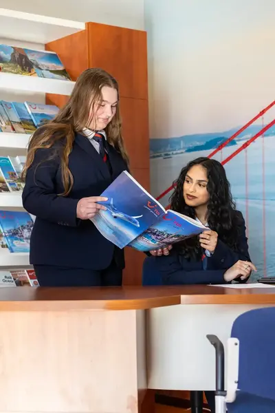 Twee studenten die naar reisbrochure kijken