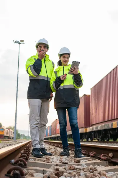 Twee studenten in werkkleding op rangeerterrein NS